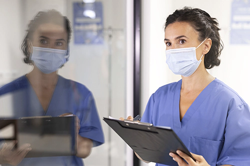 Hygienebeauftragte beobachtet Prozesse und Handlungen und notiert sich alles auf einem Blatt auf ihrem Klemmbrett.